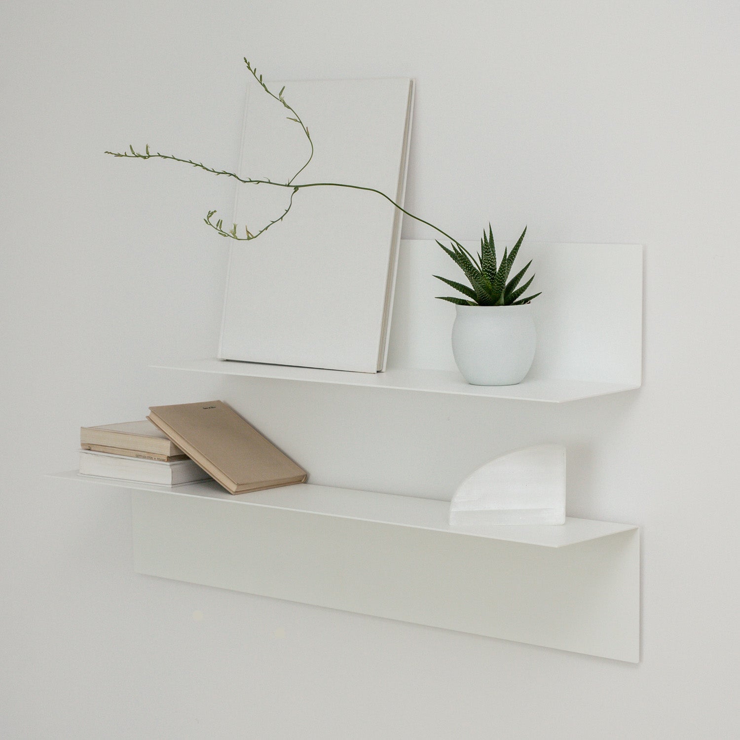 two white modern wall shelves creating a modern wall decor