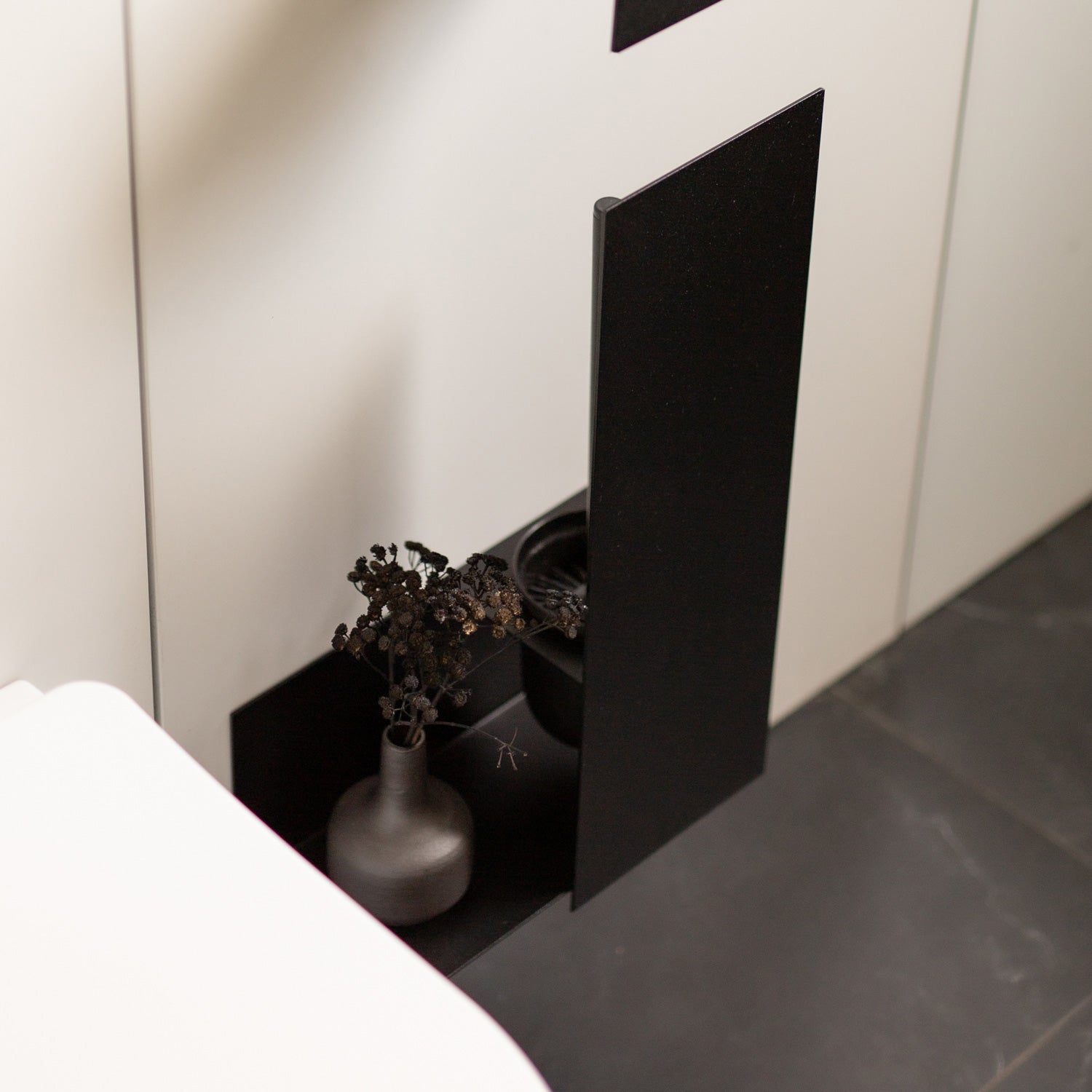 large toilet brush holder on grey tiles