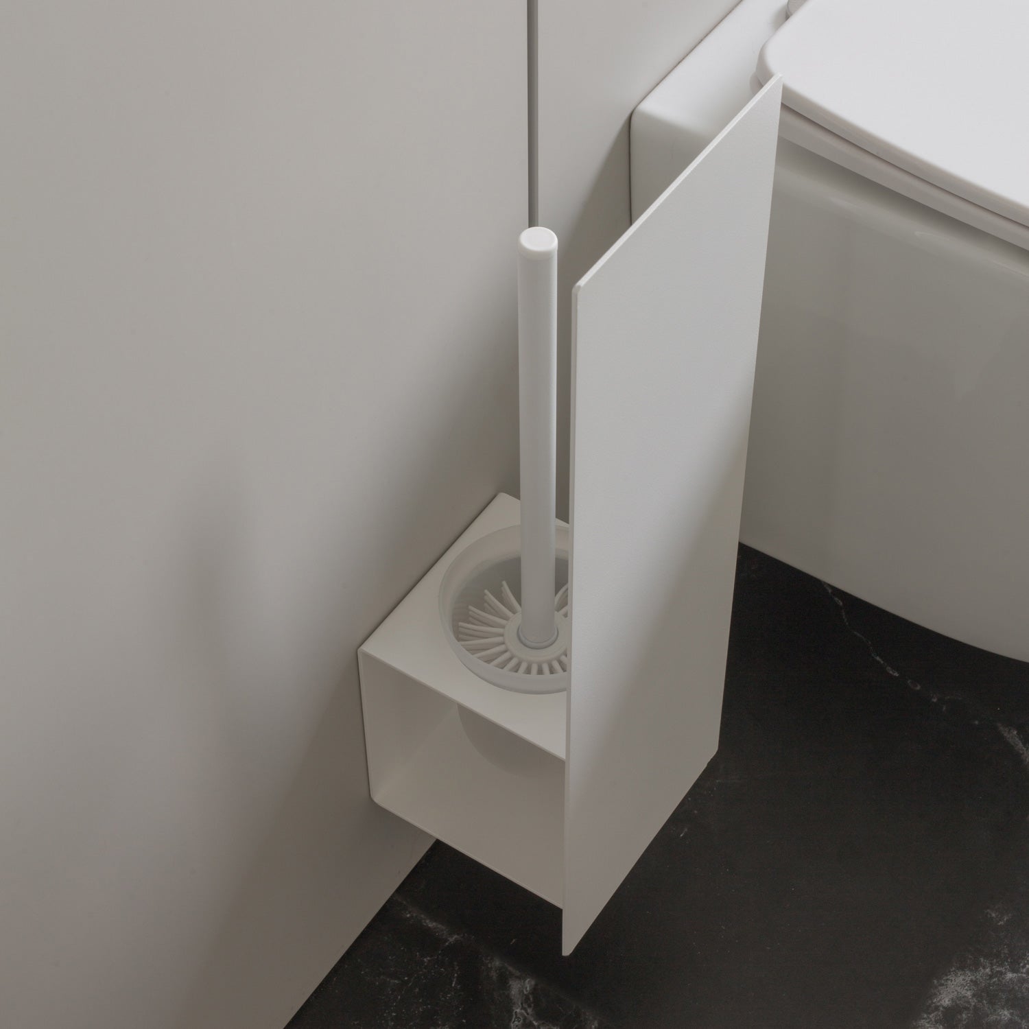 white toilet brush holder with black and white tiles