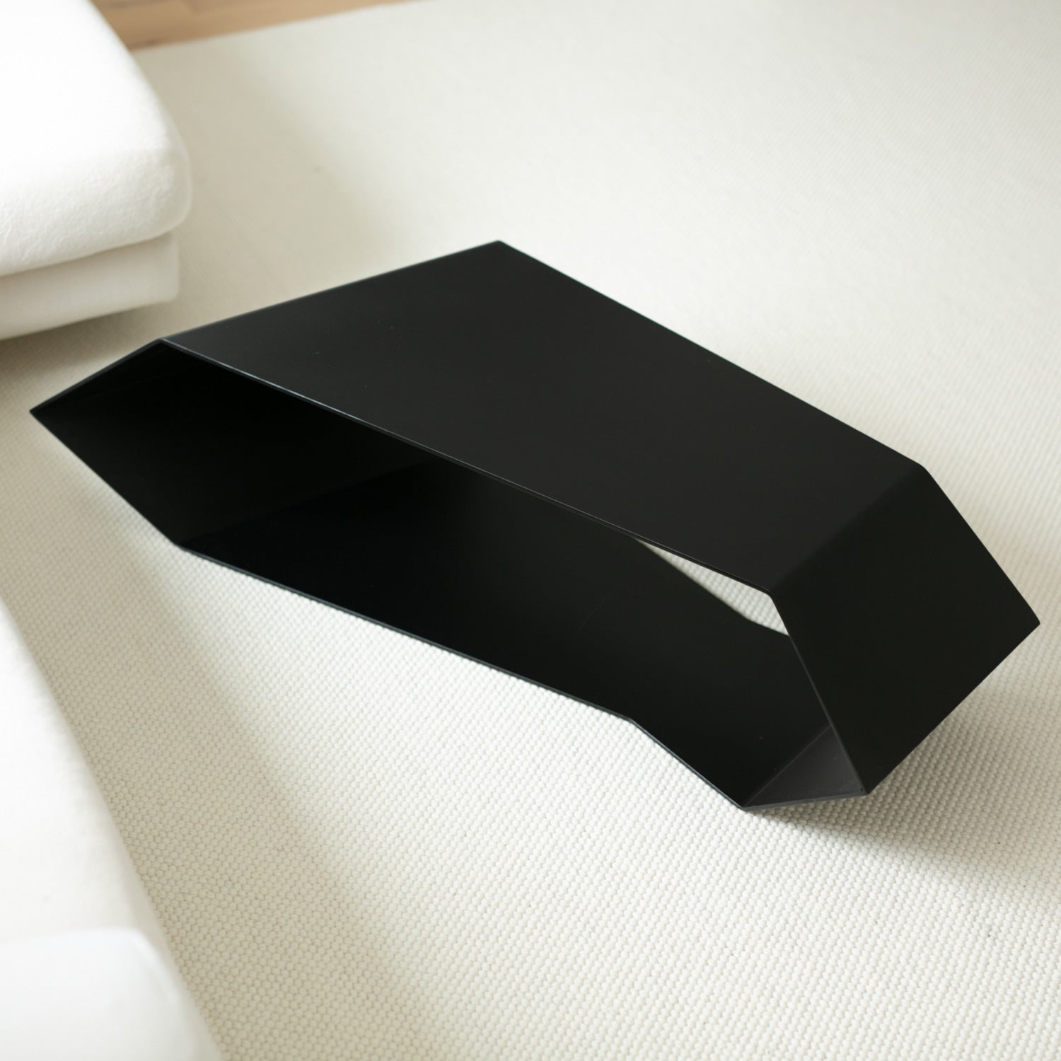Black modern coffee table on a cream carpet
